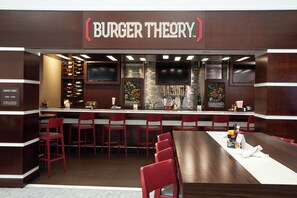 A restaurant interior with a bar area, seating, and a wine rack. - Holiday Inn & Suites Stockbridge/Atlanta I-75 by IHG (Stockbridge)