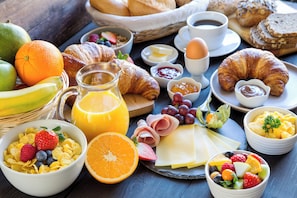 Una abundante mesa de desayuno con diversos alimentos y bebidas.