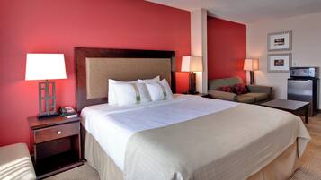 A hotel room with a large bed, bedside lamps, a desk, a chair, and a television.
