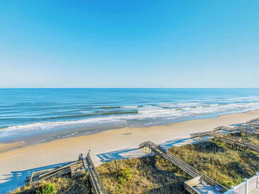 Une plage avec des promenades en bois et une vue dégagée sur l’océan.