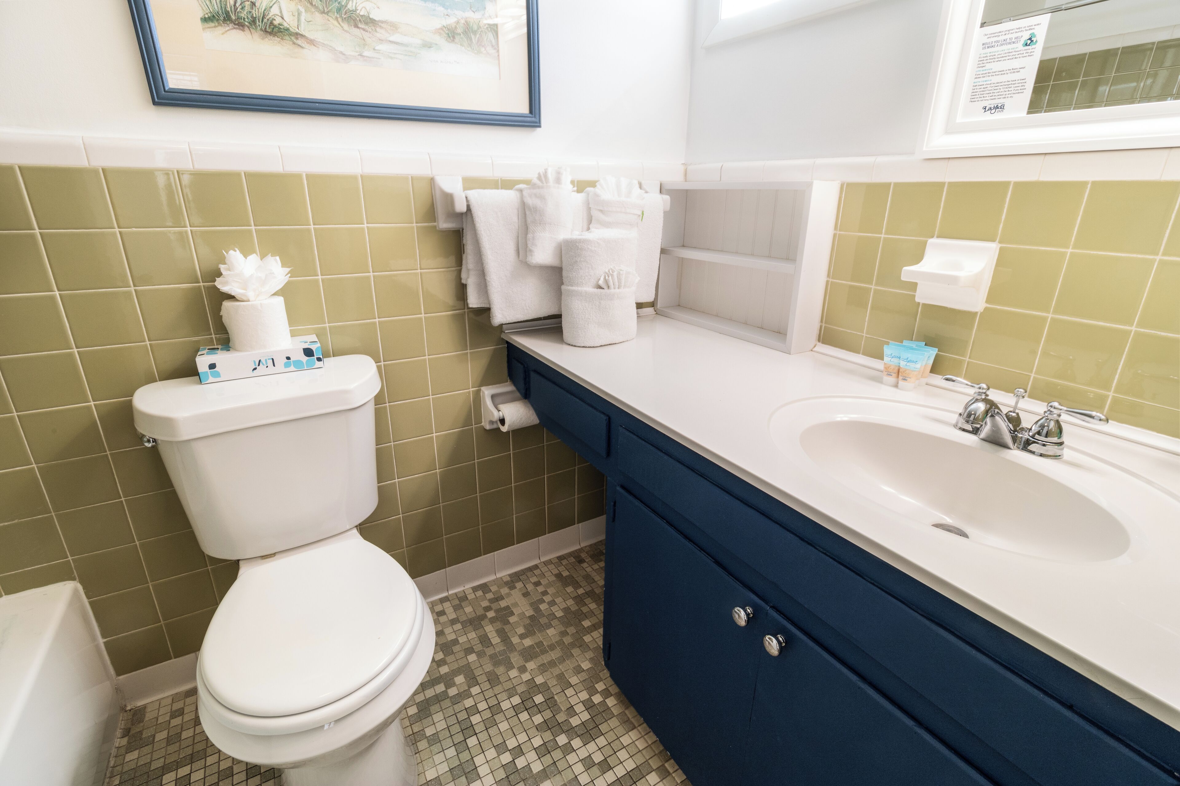 A bathroom with a toilet, a sink, and a mirror.