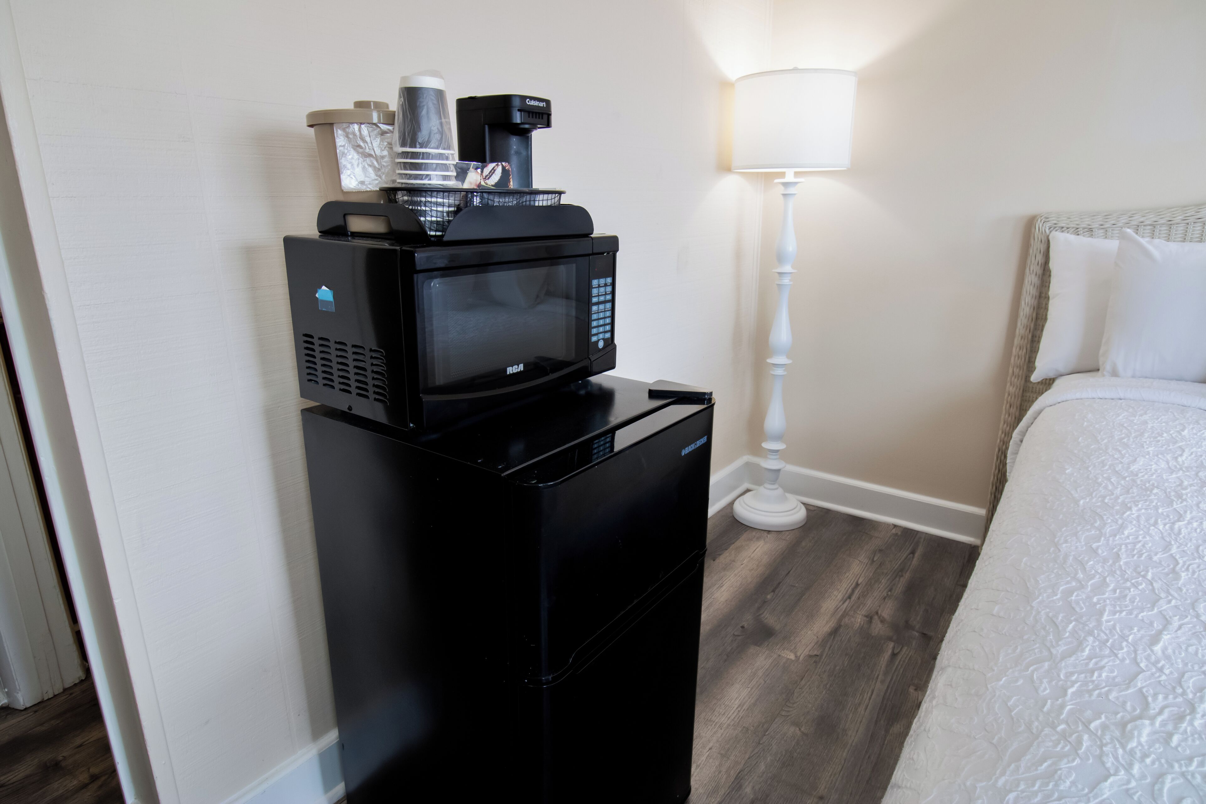 Une petite cuisine équipée d’un four à micro-ondes, d’une machine à café et d’un petit réfrigérateur.