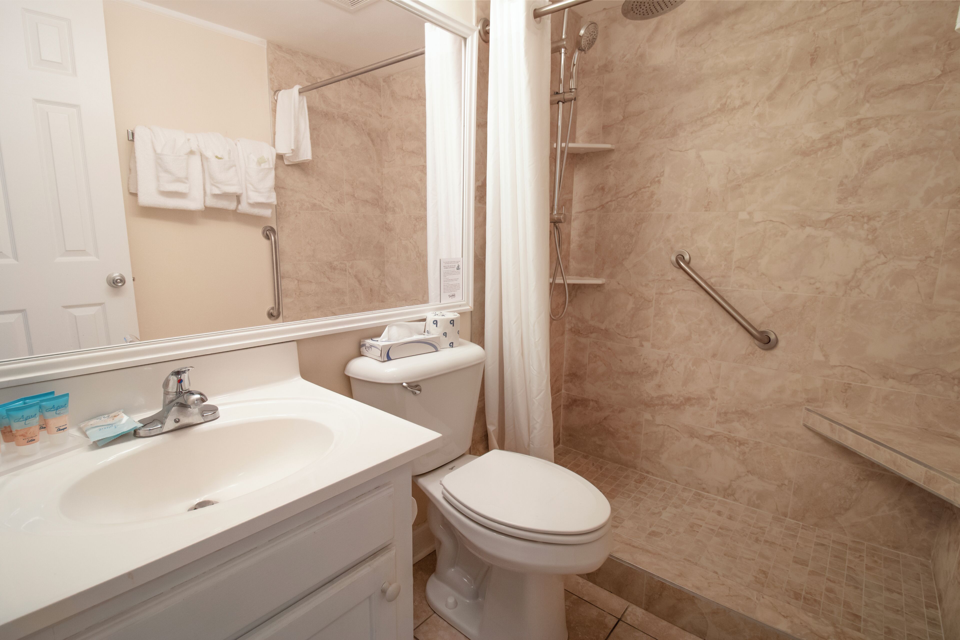 Un baño con lavamanos, inodoro y ducha.