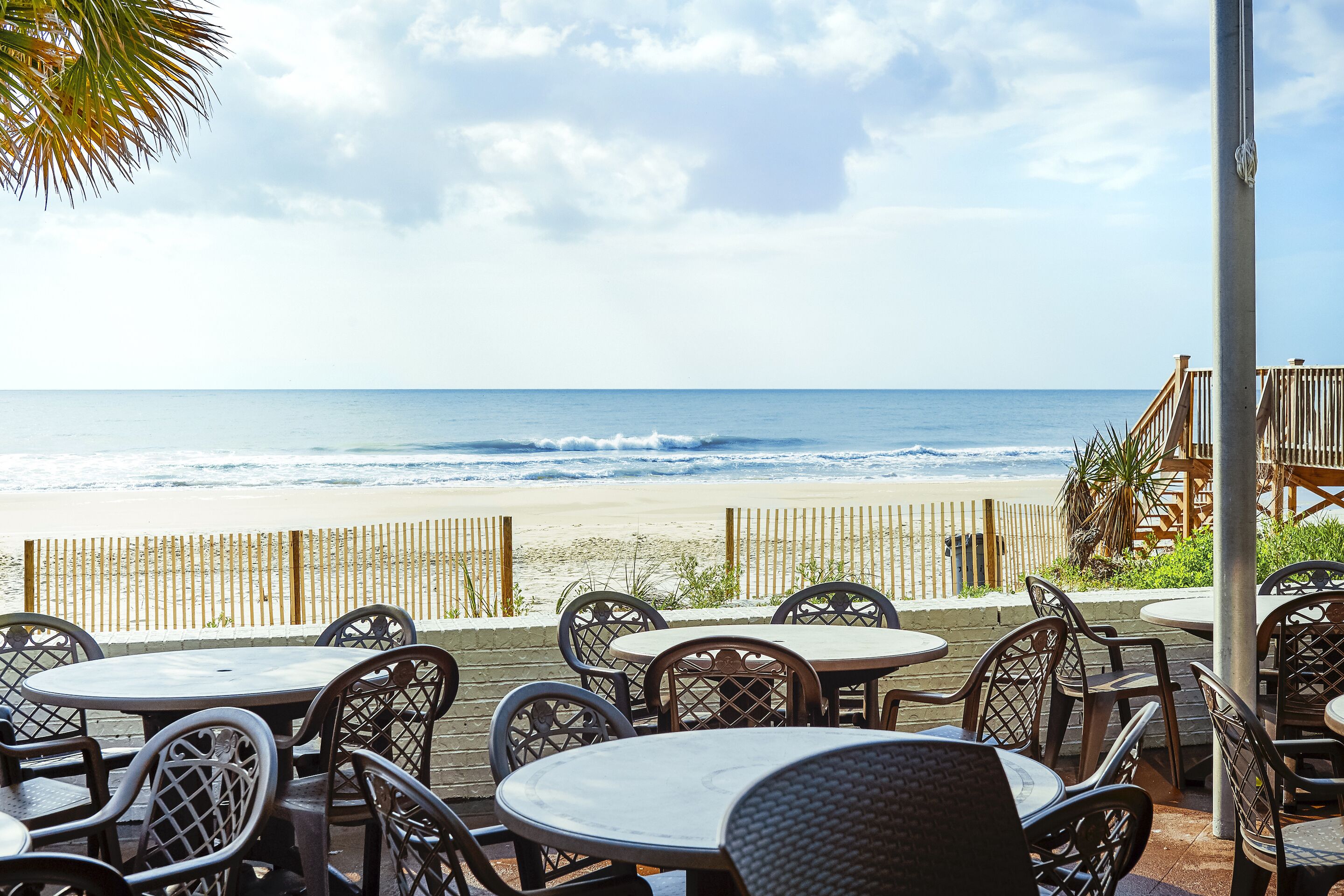 Outdoor seating with a view of the beach and ocean.