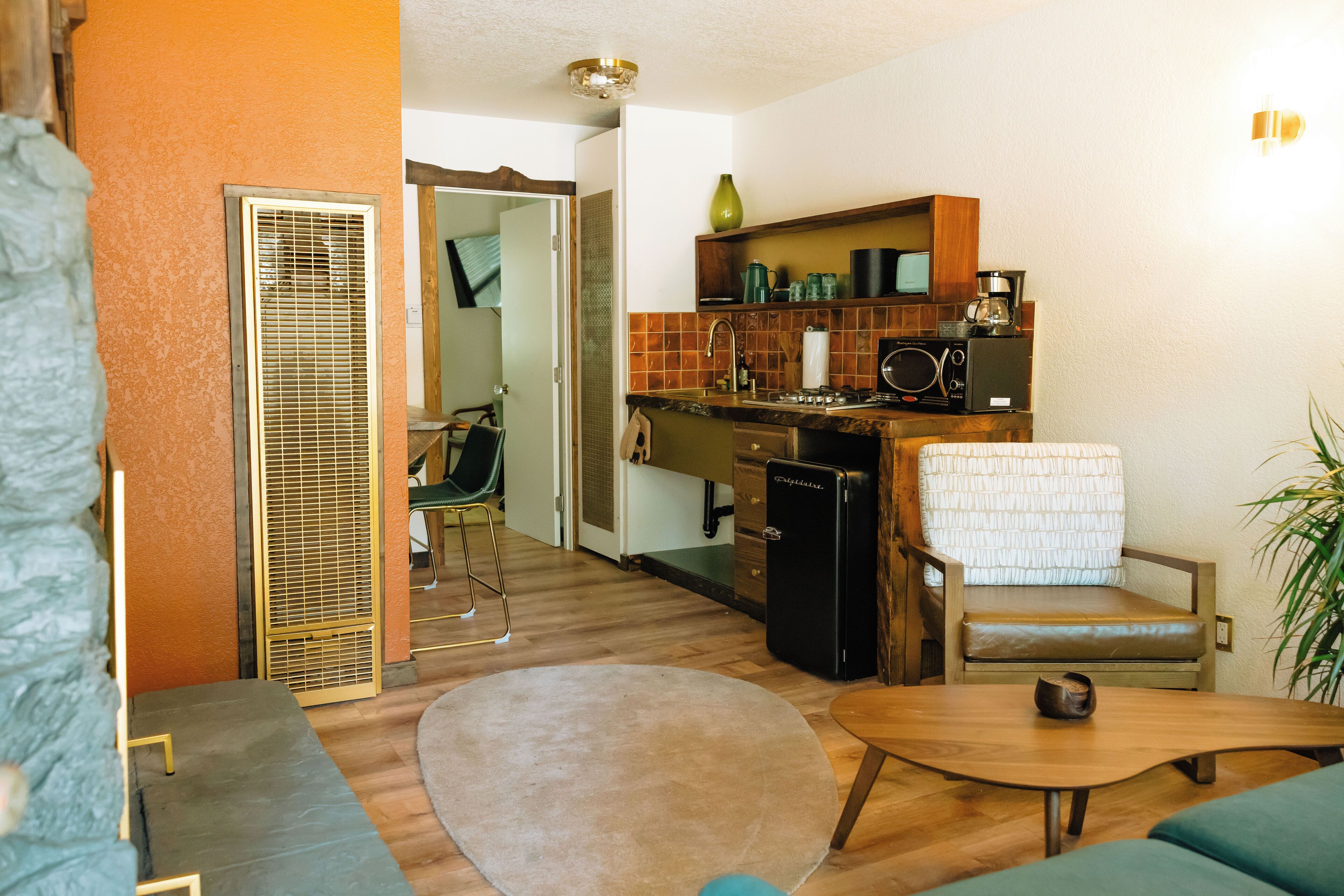 Un espacio habitable compacto con kitchenette, comedor y zona de estar.