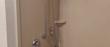 Un baño moderno con cabina de ducha, bañera y barra de apoyo.