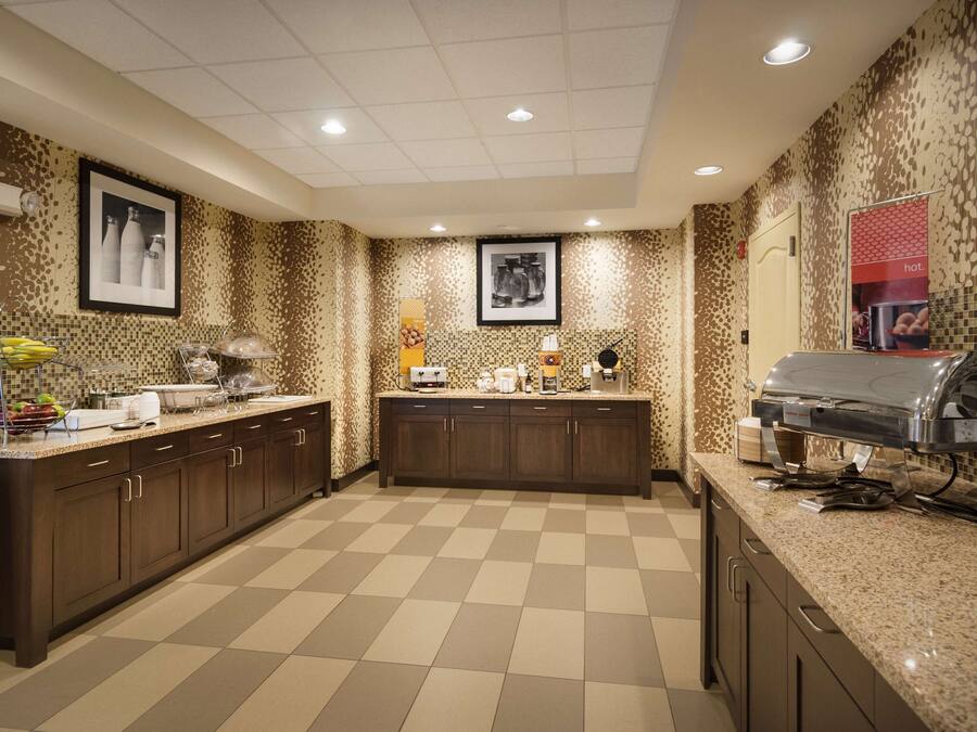A modern kitchen with a checkered floor, dark wooden cabinets, and a built-in grill station.