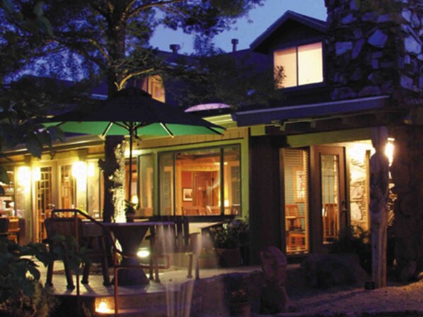 A modern house with a patio area featuring outdoor furniture and a green umbrella. - Lodge At Sedona (Sedona)