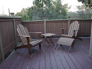 A wooden deck with two Adirondack chairs and a small table. - Lodge At Sedona (Sedona)