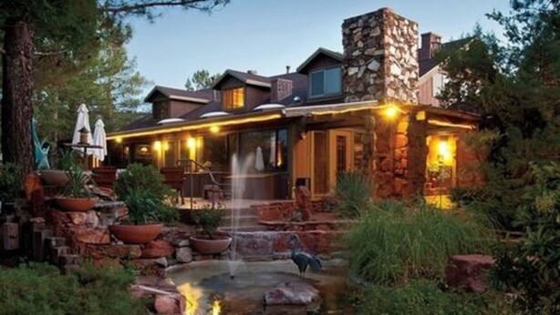 A stone building with a patio area, outdoor seating, and a small water feature. - Lodge At Sedona (Sedona)