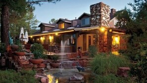 A stone building with a patio area, outdoor seating, and a small water feature. - Lodge At Sedona (Sedona)
