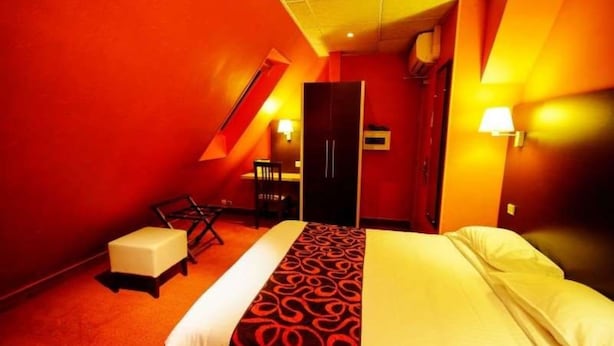 Una camera d'albergo con un letto, una scrivania e una sedia.