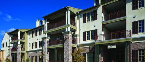 A multi-story building with a brick facade, multiple balconies, and a sign indicating it is a carriage house.