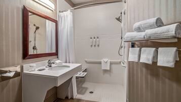 Un bagno moderno con doccia, due lavabi, uno specchio e un porta asciugamani.