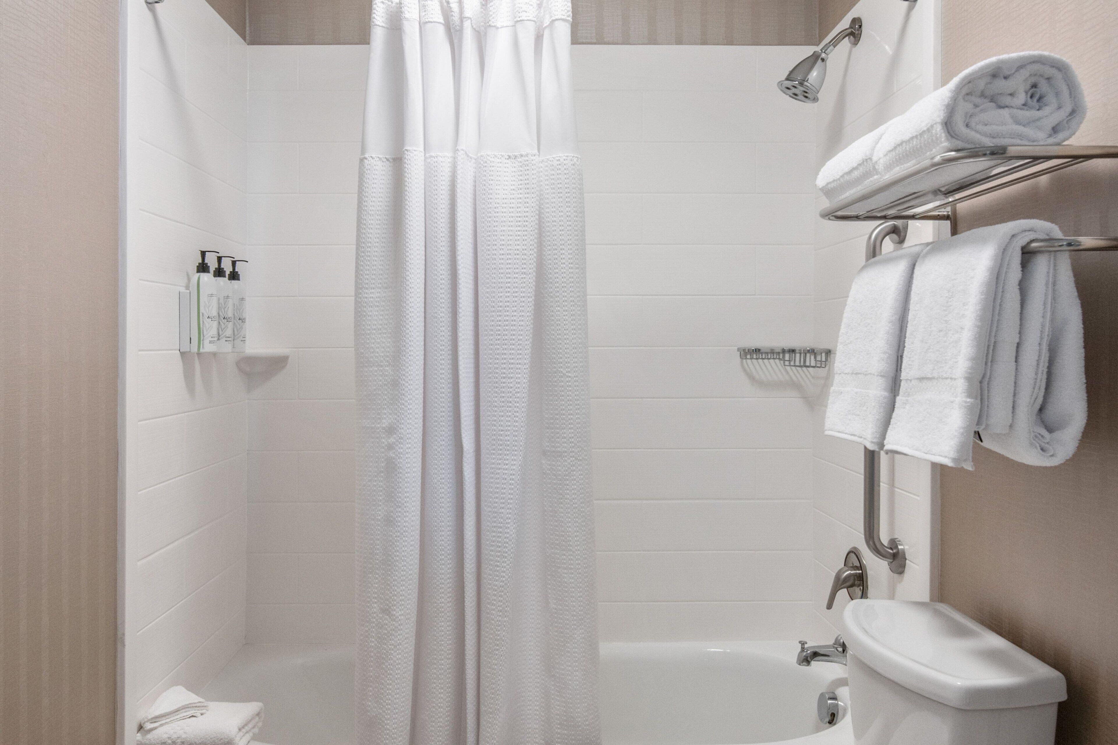 Un baño moderno con ducha, inodoro y lavamanos.