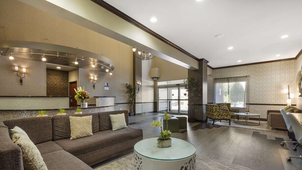 A spacious lobby with a sofa, round coffee table, and patterned walls. - Best Western Plus Duncanville/Dallas (Duncanville)