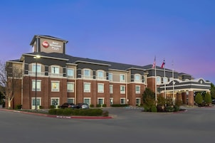 Um hotel Best Western Plus com fachada de tijolos, várias janelas e estacionamento.