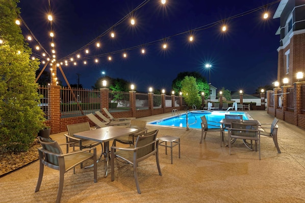 An outdoor pool area with string lights, a pool, and patio furniture. - Best Western Plus Duncanville/Dallas (Duncanville)