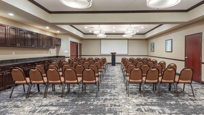 A conference room with rows of chairs, a podium, and a carpeted floor. - Best Western Plus Duncanville/Dallas (Duncanville)