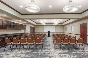 A conference room with rows of chairs, a podium, and a carpeted floor. - Best Western Plus Duncanville/Dallas (Duncanville)