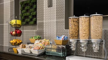 A breakfast bar with various food items and a coffee machine.