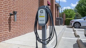 An electric vehicle charging station mounted on a brick wall. - Best Western Plus Duncanville/Dallas (Duncanville)