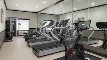 A gym with treadmills, elliptical machines, and a stationary bike.