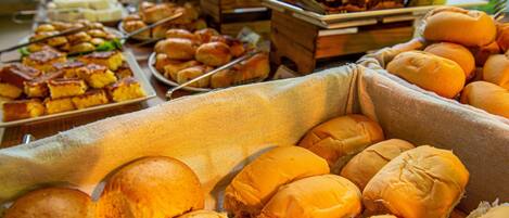 Un bufé con diversos alimentos, incluyendo sándwiches, pasteles y otros platos.