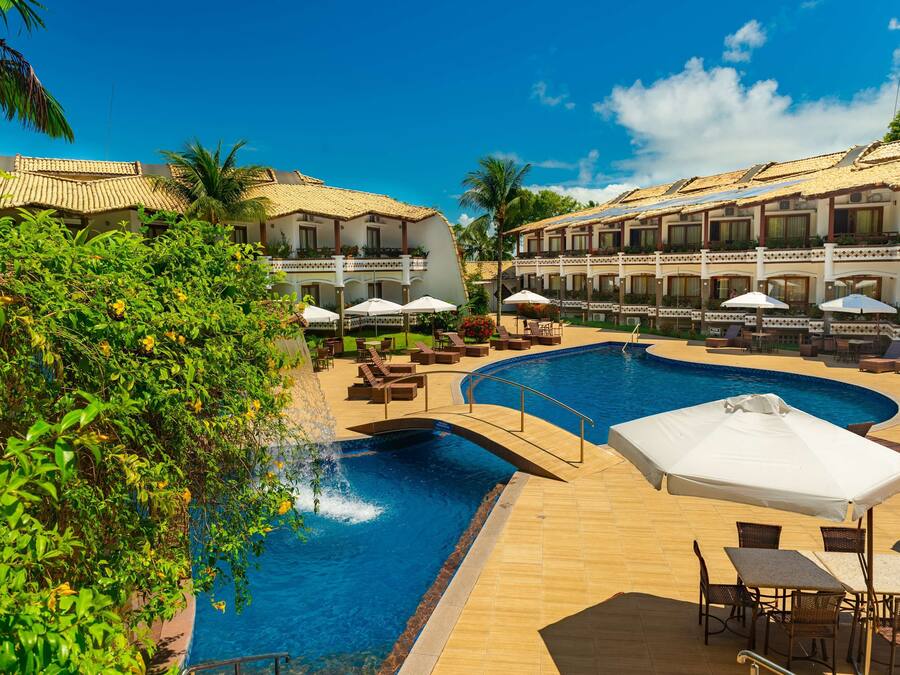 Een resort met een zwembad, ligbedden en parasols.