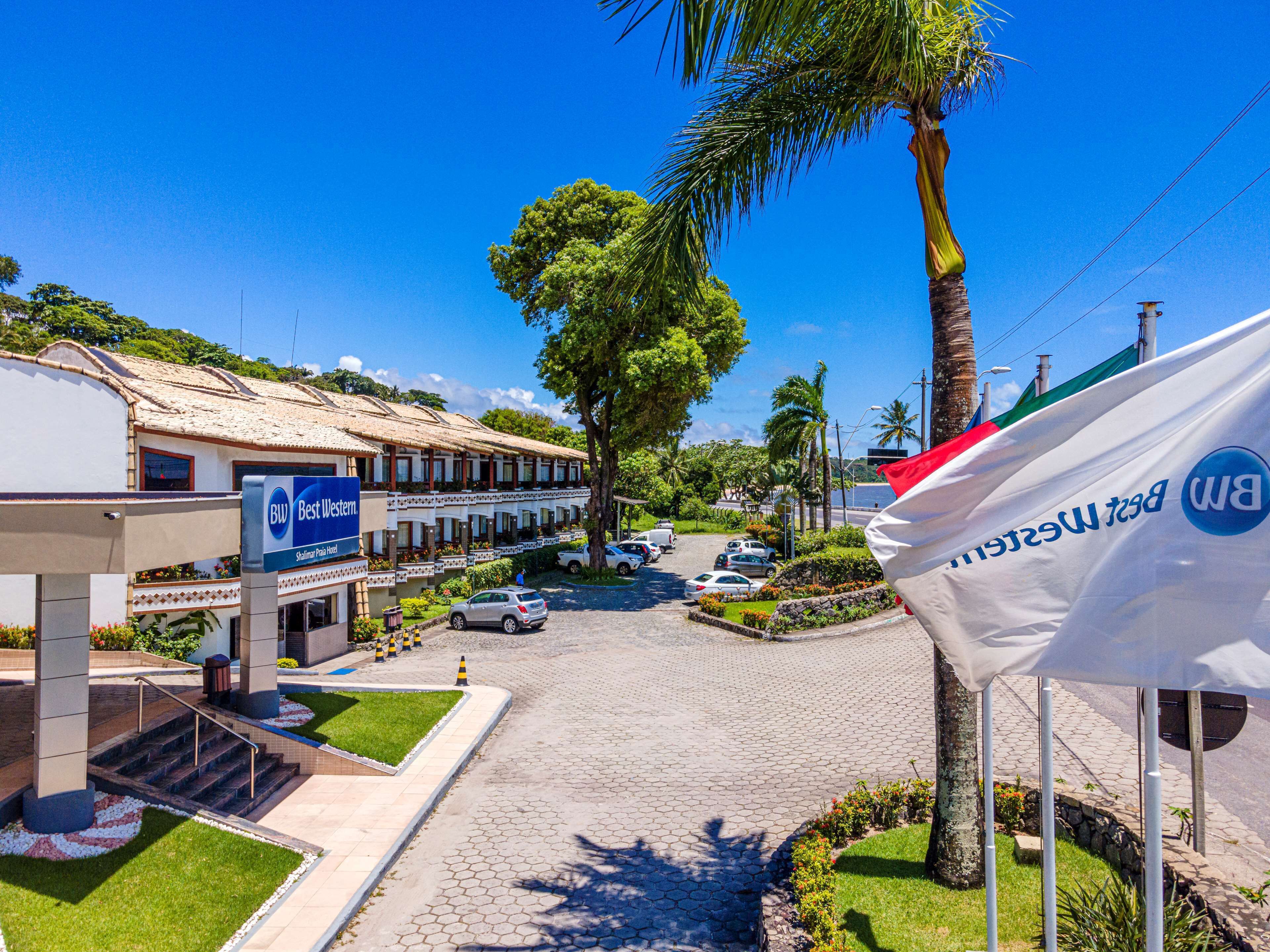 Un hôtel avec une enseigne indiquant « Best Western » et un palmier au premier plan.