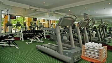 A gym with treadmills, dumbbells, and exercise equipment.