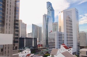 A cityscape with modern high-rise buildings, including a distinctive twisted skyscraper. - Yellow Ribbon Hills, Boutique Suites (Bangkok)
