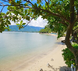 Am Strand, weißer Sandstrand, Liegestühle, Sonnenschirme