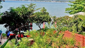 A coastal view with lush greenery, a beach, and a mountain in the background. - Cinnamon Beach Villas (Koh Samui)