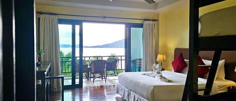 A hotel room with a bed, a desk, and a view of the outdoors.