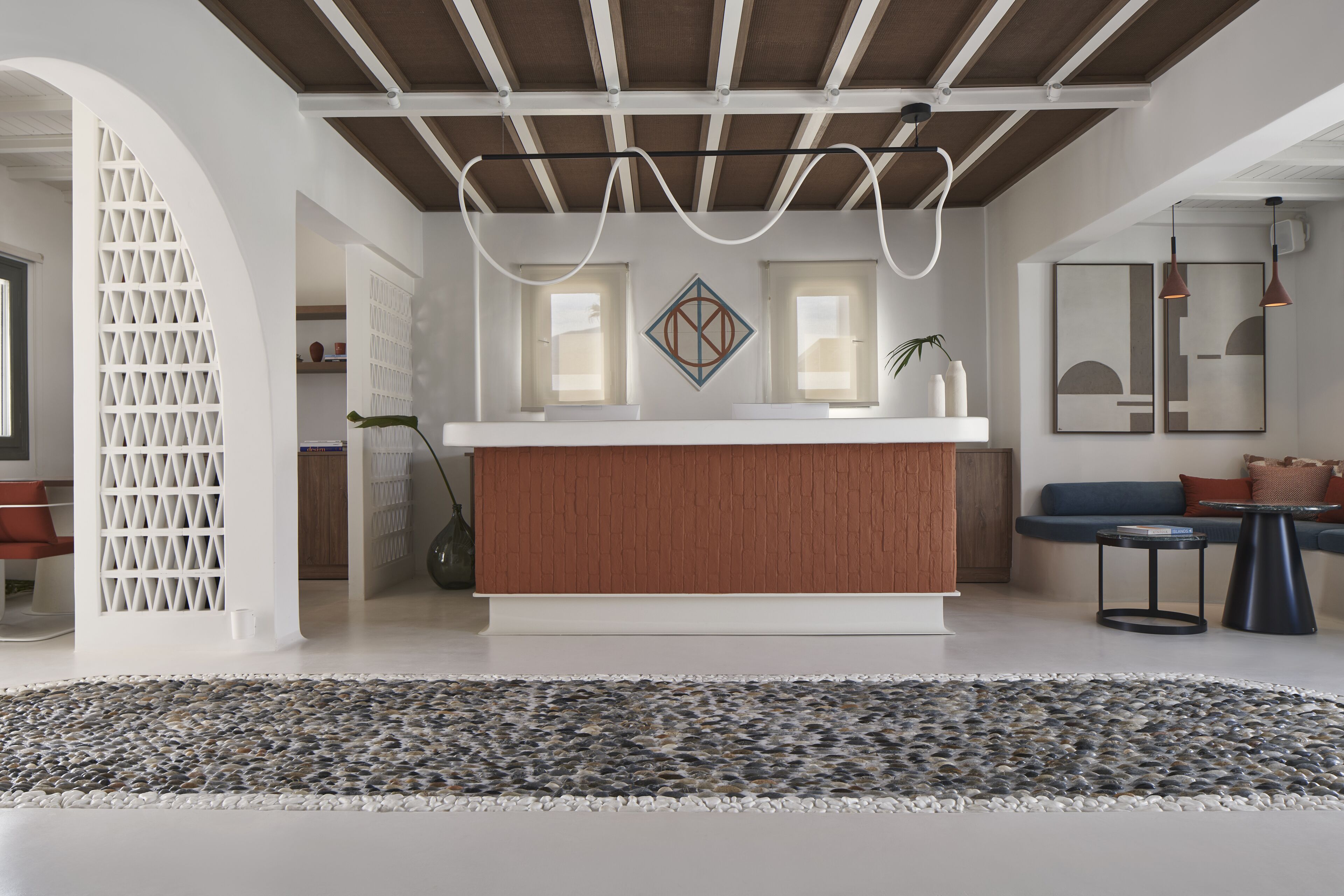 A modern kitchen with a wooden countertop, a white backsplash, and pendant lighting.