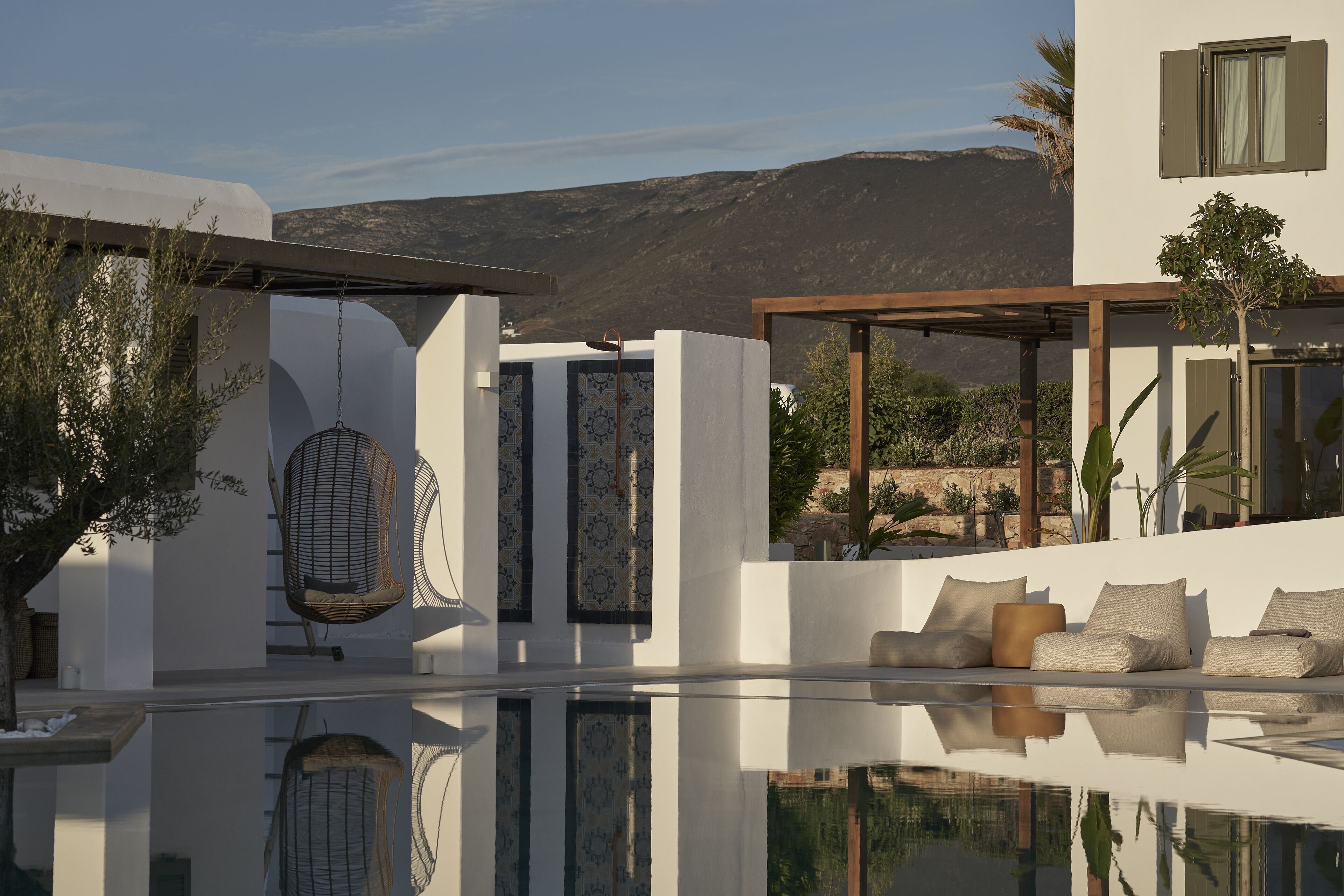Un área de piscina moderna al aire libre con una vista despejada de las montañas al fondo.