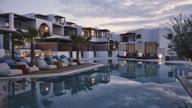 A modern resort with a pool, outdoor seating, and multiple levels of balconies.