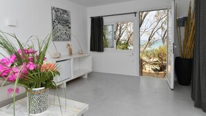 A modern room with a large window, a white console table, a decorative plant, and a view of the outdoors.