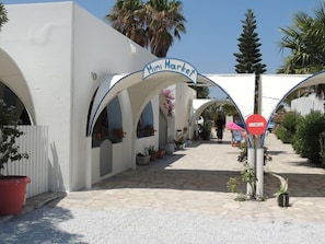 A white building with a sign reading "Mini Market" and a red "no entry" sign.