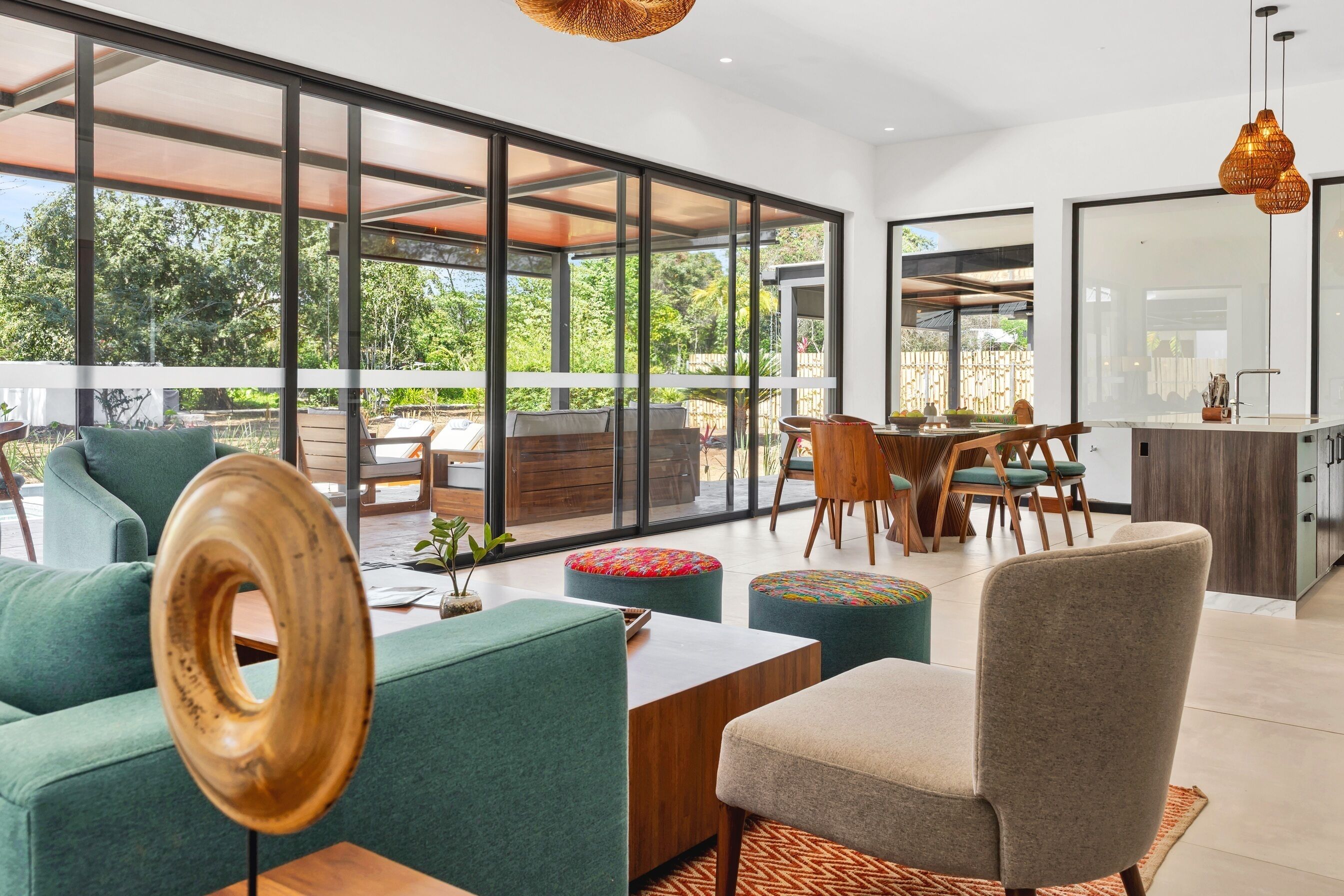 A modern interior with large windows, a dining area, and a kitchen.