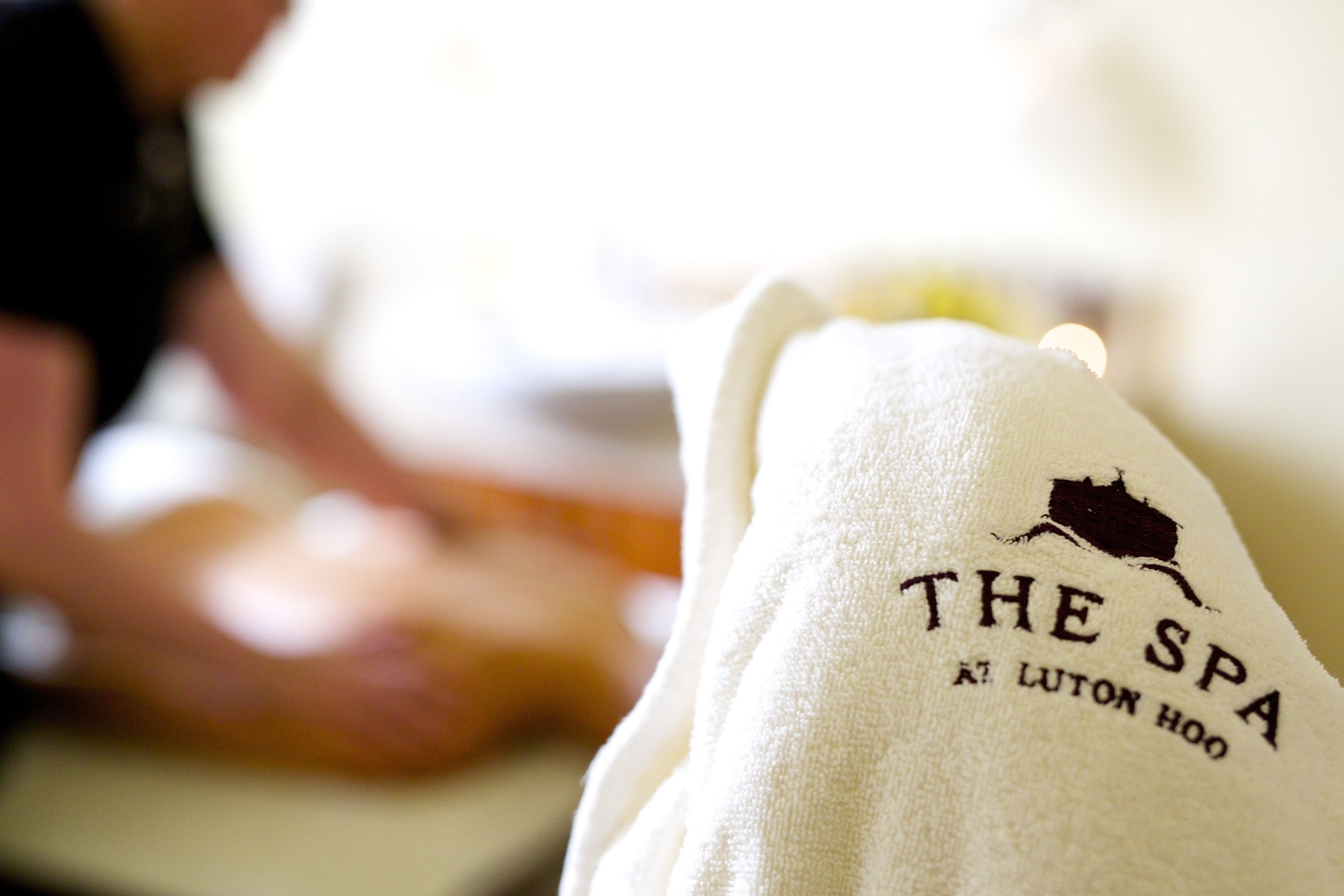 A towel with "THE SPA" and "LUTON HOO" printed on it.