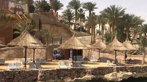 A resort with clear waters, palm trees, and thatched-roof structures. - Jolie Ville Royal Peninsula Hotel & Resort Sharm El Sheikh (Sharm El Sheikh)