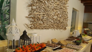 A buffet setup with various food items and a decorative wall piece. - Pacífica Resort Ixtapa All-Inclusive (Ixtapa)