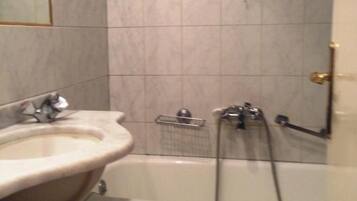 Un baño con lavamanos, espejo y bañera.