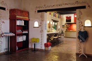 Vestíbulo de hotel con recepción, zona de estar y exhibición de textiles.