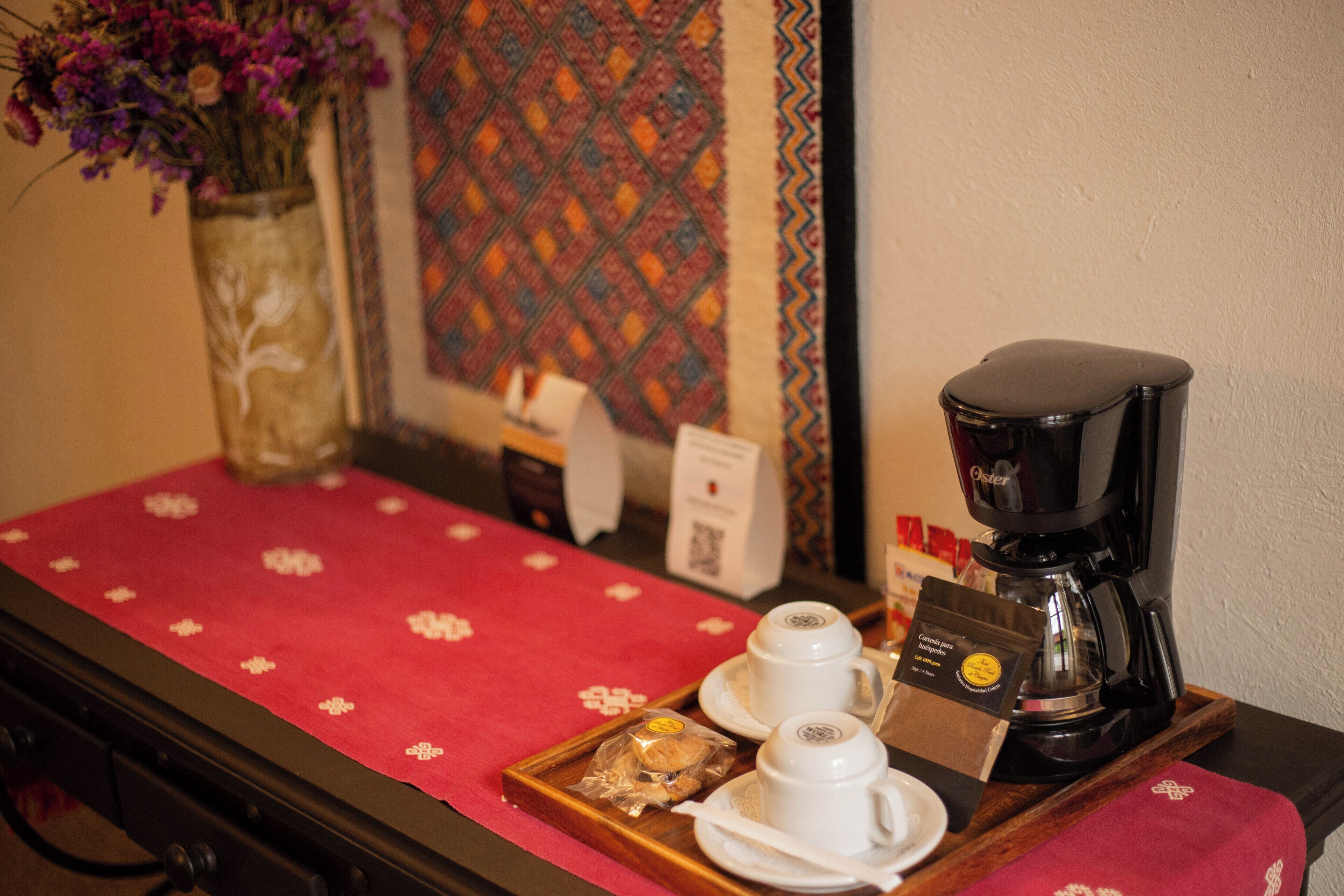 Un coin café équipé d’une machine à café, de tasses et d’un plateau de viennoiseries.
