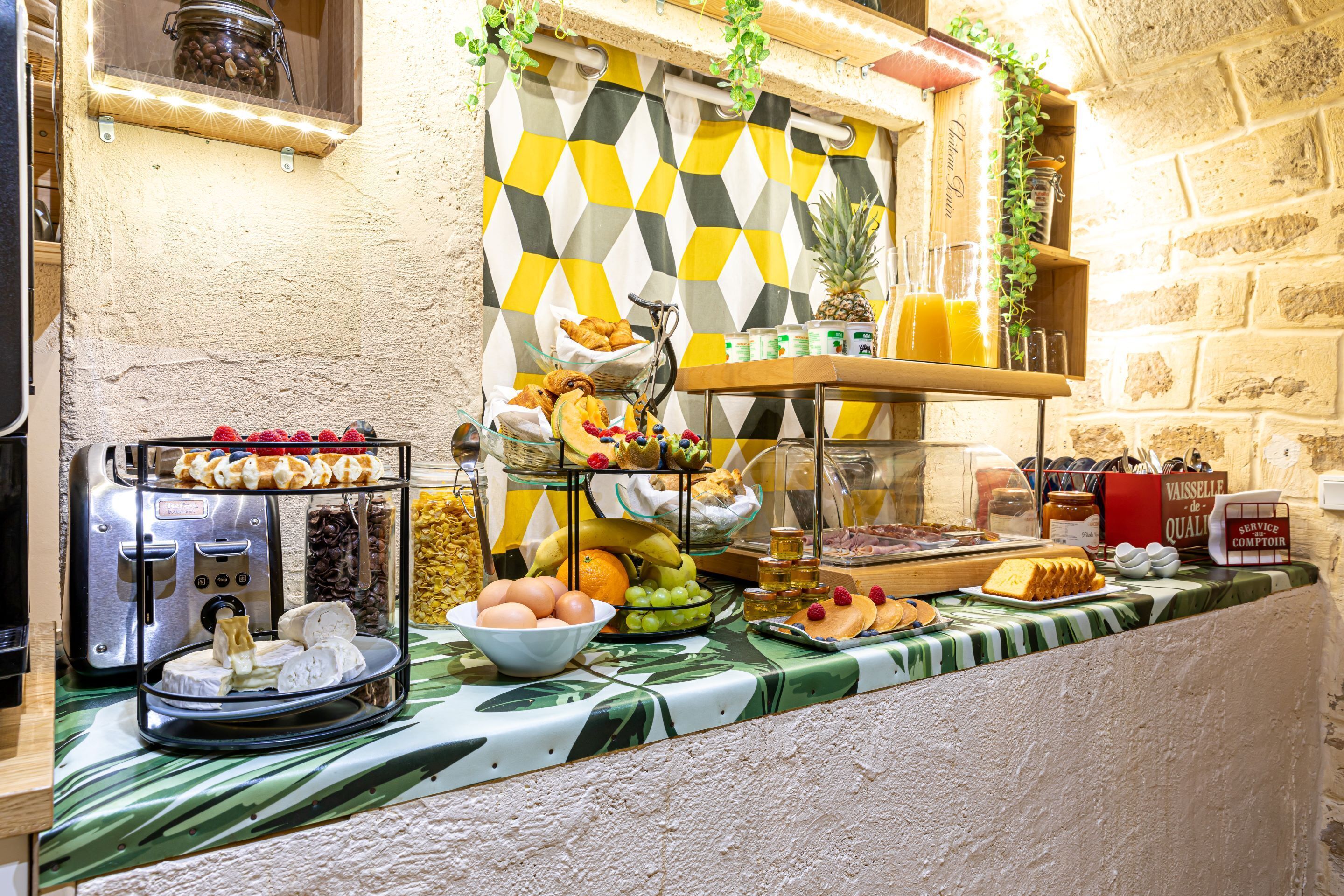 A breakfast buffet with various food items, including fruits, pastries, and beverages.