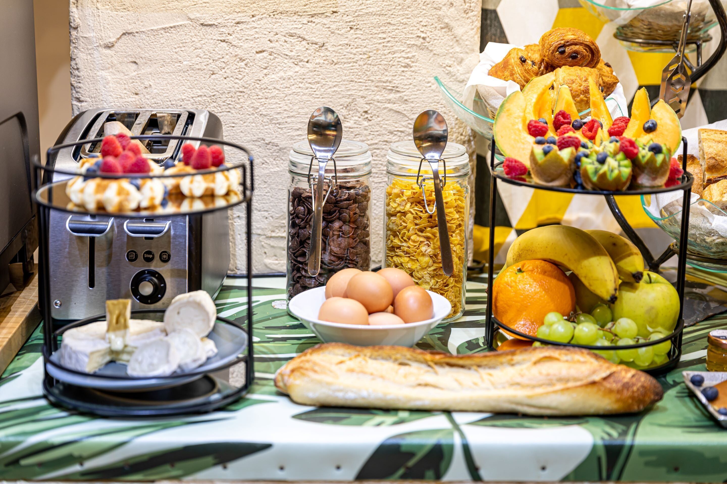 Un bufé de desayuno con diversas opciones de comida y un tostador.