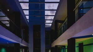 A modern building with a central atrium, multiple floors, and large windows allowing natural light. - Hotel Flamingo (Merida)